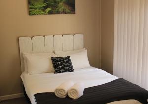 a bedroom with a bed with two towels on it at Snow Gum Apartment 1 in Baw Baw Village