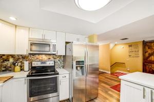 una cocina con armarios blancos y electrodomésticos de acero inoxidable en 6 Bedroom House at Schroon River, en Brant Lake