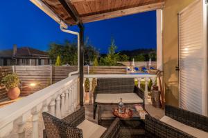 Un patio con una mesa y sillas en un balcón. en Toscana Villas, en Gaïtánion