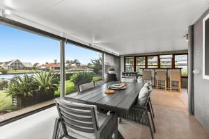 a dining room with a table and a large window at Bribie Island Canal Holiday Destination! in Bongaree