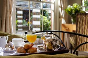 a table with a tray of breakfast food and orange juice at Lainston House in Winchester