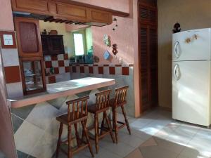 a kitchen with a refrigerator and a table and chairs at Casa Roja Áabilo'ob in Progreso