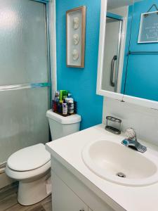 uma casa de banho com um WC branco e um lavatório. em Treasure Island 1BR Beach condo with Gulf View em St. Pete Beach