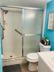 uma casa de banho com um chuveiro, um WC e um lavatório. em Treasure Island 1BR Beach condo with Gulf View em St. Pete Beach