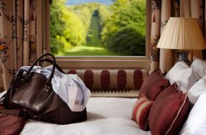 a purse sitting on top of a bed with a window at Lainston House in Winchester