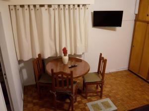 een kamer met een tafel en stoelen en een televisie bij Cortina in Buenos Aires