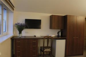 a kitchen with wooden cabinets and a table with a vase of flowers at Elena in Palanga +21 photos