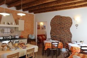 una cocina con 2 mesas y una pared de ladrillo en B&B Acero Rosso, en San Giovanni Lupatoto