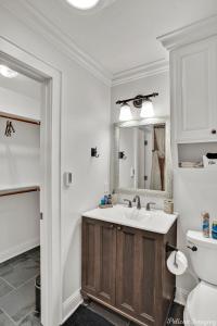 a bathroom with a sink and a toilet and a mirror at Lakefront Fully Loaded Apartment in Shreveport