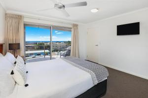 a hotel room with a large bed and a large window at Rovera Apartments in Maroochydore