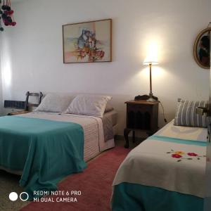 1 dormitorio con 2 camas, mesa y lámpara en Bed & Breakfast Pleno Centro EN CASA PARTICULAR en San Luis