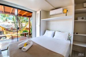 a bedroom with a bed with towels on it at Pousada Rosa in Praia do Rosa +37 photos