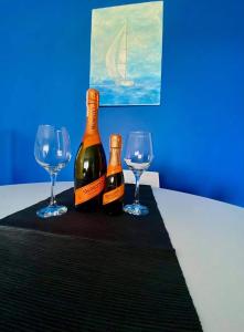 twee flessen wijn en twee glazen op een tafel bij Apartamenty Pod Żaglami in Zegrze