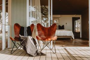 two chairs and a bed in a bedroom at Evamor Valley in Mudgee