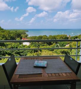 a table on a balcony with a view of the ocean at Appartement T2 Sainte Anne Caritan Melody Sunset in Caritan
