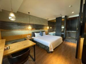 屏東市的住宿－六本木MOTEL-大連館，一间卧室配有一张床、一张桌子和一张书桌