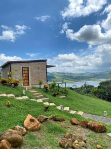 a building on top of a hill with rocks in the grass at ADAMA BIOHOTEL in Calima