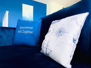 Un sofá azul con dos almohadas. en Apartamenty Pod Żaglami, en Zegrze