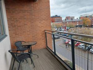 a balcony with two chairs and a table on a building at Large 2 Bed, 2 Bath, Free Parking & WiFi in Sheffield