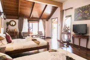 a large room with two beds and a television at West Key Kamala Villa in Kamala Beach