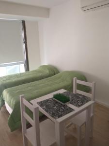 Cette chambre comprend un lit, une table et des chaises. dans l'établissement Verde Esmeralda, à Buenos Aires