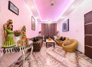 a living room with pink walls and a couch at Rainbow Home Stay in Agra