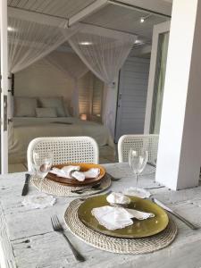 a table with a green plate and two glasses and a bed at Uluwatu Penthouse in Uluwatu