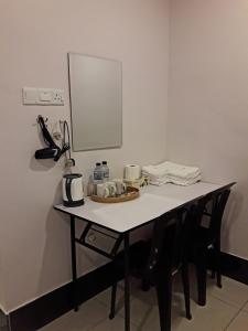 a table in a room with a mirror and a table with a tea kettle at De Benz Inn in Malacca