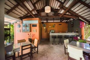 a dining room with a table and a bar at Monaburi Boutique Resort in Rawai Beach