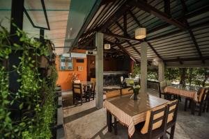 a patio with a wooden table and chairs at Monaburi Boutique Resort in Rawai Beach