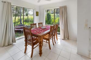 a dining room with a table and chairs and windows at Lakes Edge in Lakes Entrance