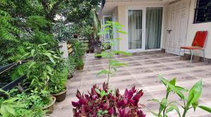 a porch with a bunch of plants and a red chair at Dula HomeStay in Guwahati