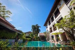 a swimming pool in front of a building at Monaburi Boutique Resort in Rawai Beach