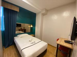 a hotel room with a bed and a television at Smile Hotel Selayang Point in Batu Caves