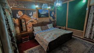 heritage geneva house boat في سريناغار: غرفة نوم صغيرة مع سرير ولوحة على الحائط