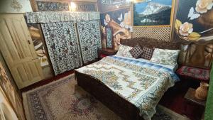 a bedroom with a bed in a room with paintings at heritage geneva house boat in Srinagar