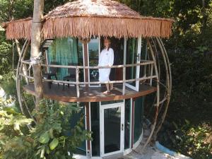 a woman standing in a round tree house at MyRus Resort Langkawi in Pantai Cenang