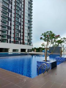 a swimming pool with a tree and a building at MyHome 2B At Seri Kembangan With A View in Seri Kembangan