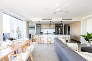 sala de estar y cocina con sofá y mesa en Dune Beachfront Apartments by Kingscliff Accommodation, en Kingscliff