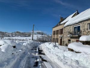 una calle cubierta de nieve junto a un edificio en Fontanies en Aubrac, en Laguiole
