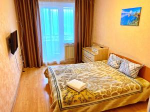 1 dormitorio con 1 cama en una habitación con ventana en Baikal Apartments at Vzletka - Krasnoyarsk, en Krasnoyarsk
