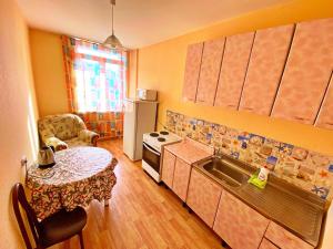 a small kitchen with a table and a sink at Baikal Apartments at Vzletka - Krasnoyarsk in Krasnoyarsk