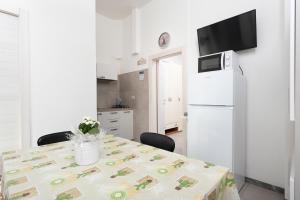 una cucina con tavolo e frigorifero bianco di Nicola House "Torre San Michele" a Cervia