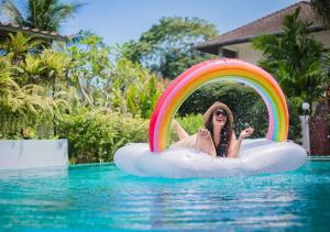 a woman is riding on a raft in a swimming pool at Monaburi Boutique Resort in Rawai Beach