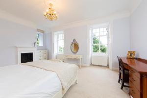 a bedroom with a bed and a desk and a mirror at Swansea Valley Holiday Cottages in Cilybebyll