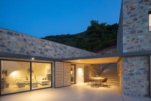 a house with sliding glass doors and a patio at Kechria Bay Villas in Skiathos