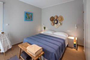 a bedroom with a blue bed and a wooden table at Kechria Bay Villas in Skiathos