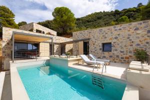 a villa with a swimming pool and a house at Kechria Bay Villas in Skiathos