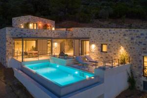 a villa with a swimming pool at night at Kechria Bay Villas in Skiathos