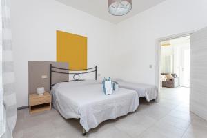 una camera con due letti e una parete gialla e bianca di Nicola House La Salina a Cervia
